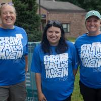 Three volunteers standing together and smiling